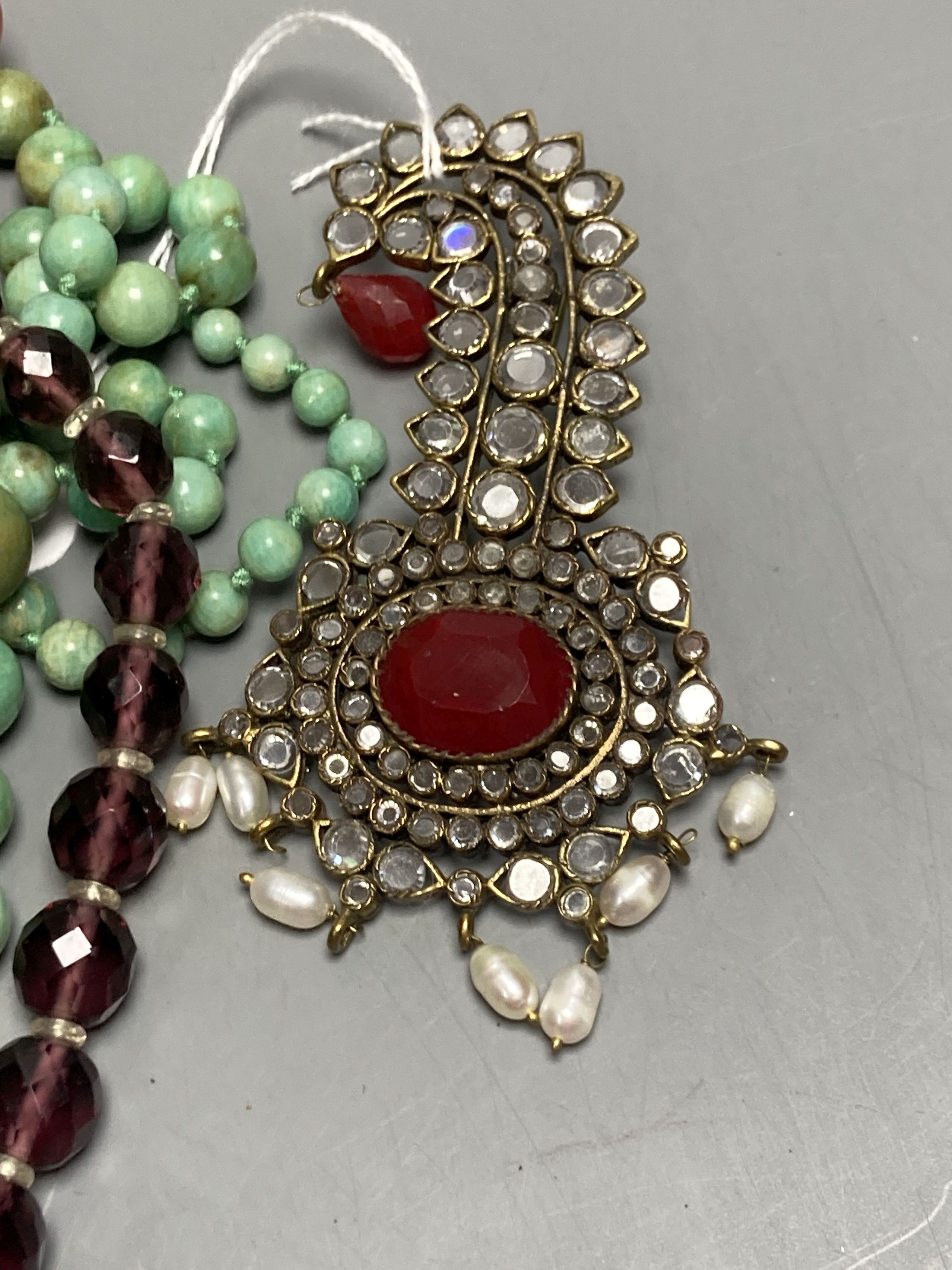 A turquoise bead necklace and pair of earrings, two other necklaces and two brooches including Indian? paste set.